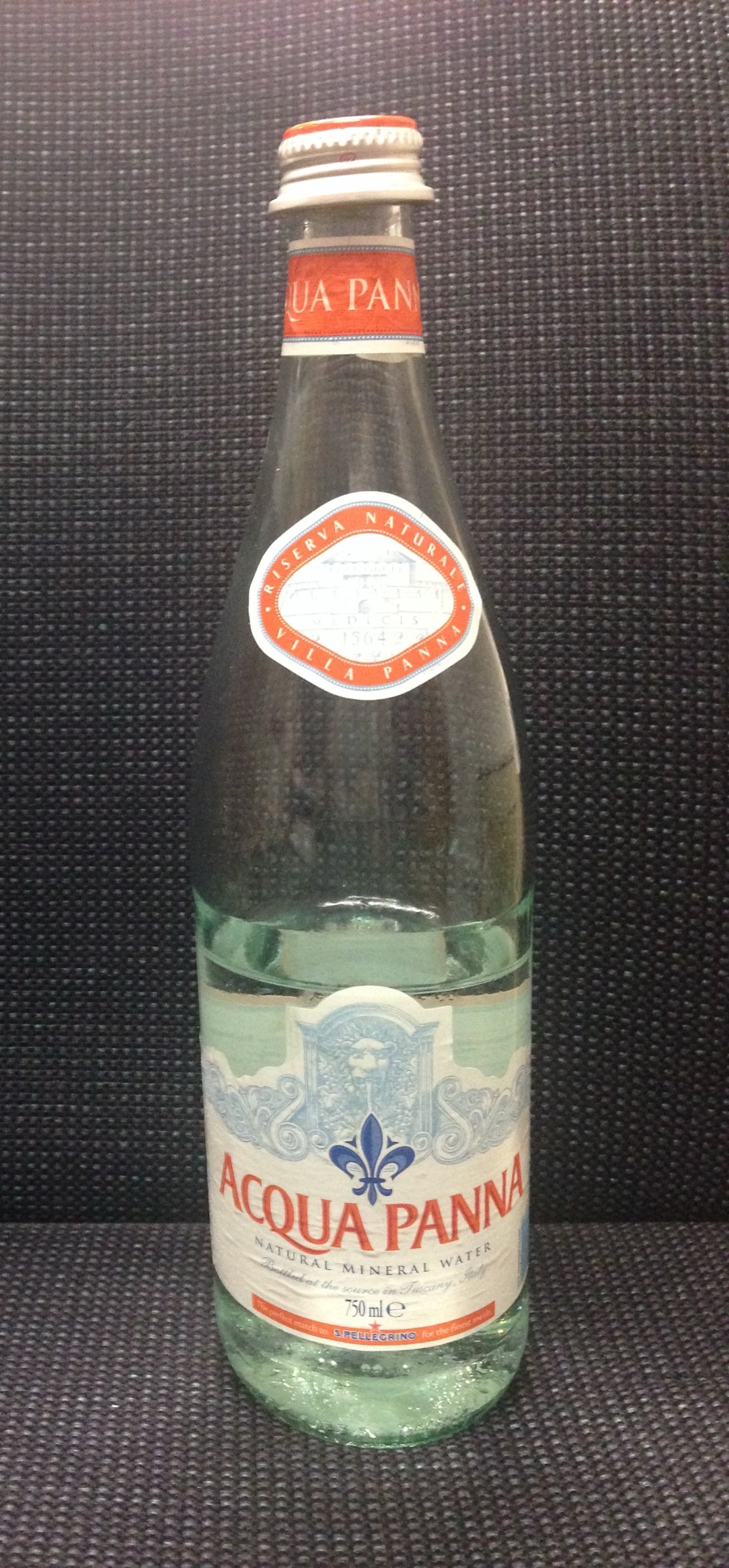 A glass bottle of natural mineral water. By law it left its source undisinfected, with its minerals intact and declared on the label.