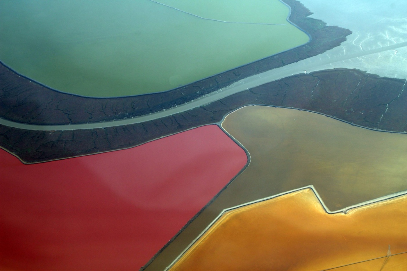 Evaporation ponds on San Francisco Bay, from the air. The colours are the brine itself: the saltier the pond, the redder the microbes that live in it.