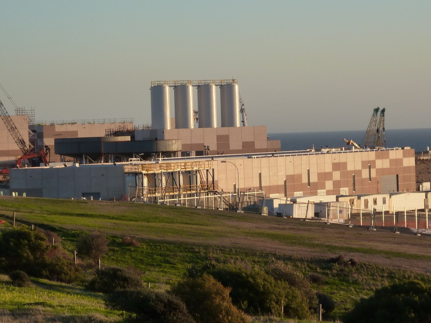 A seawater desalination plant on the coast. The intake is in the sea, and the outfall is not far from it.