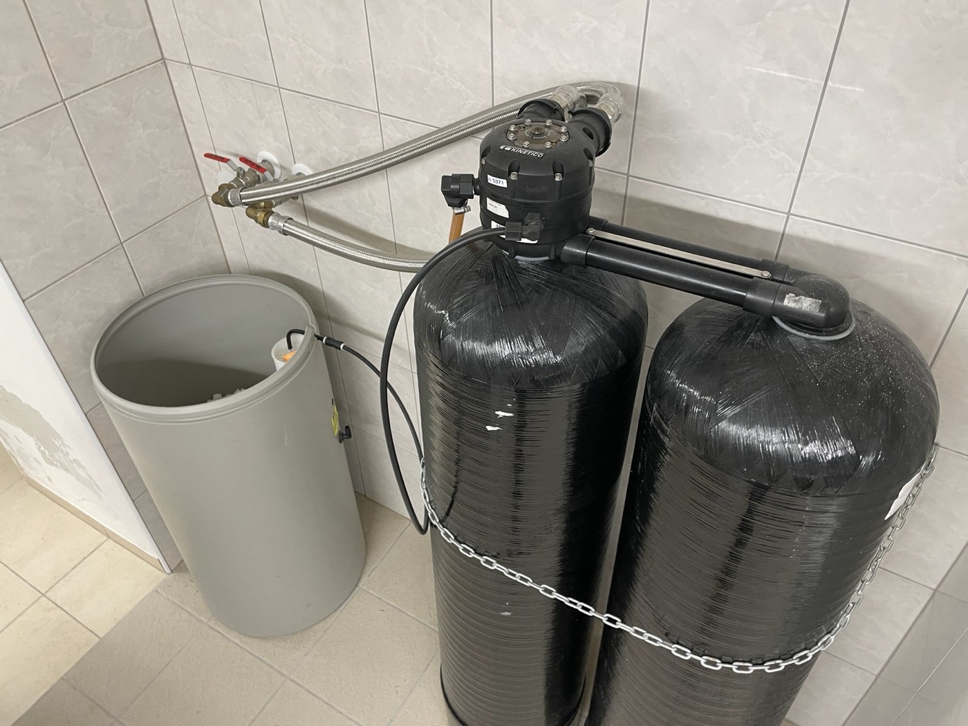A household water softener: two resin tanks and a brine tank. It swaps calcium for sodium.