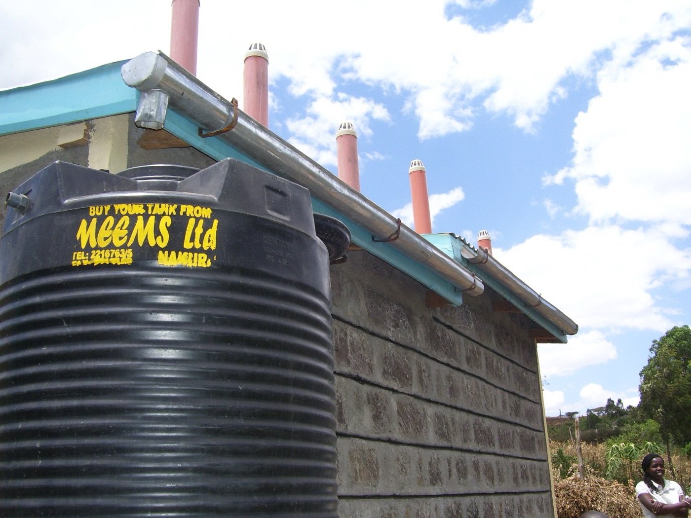 A rainwater tank beside a house in Kenya. The roof is the catchment and the tank is the cost.