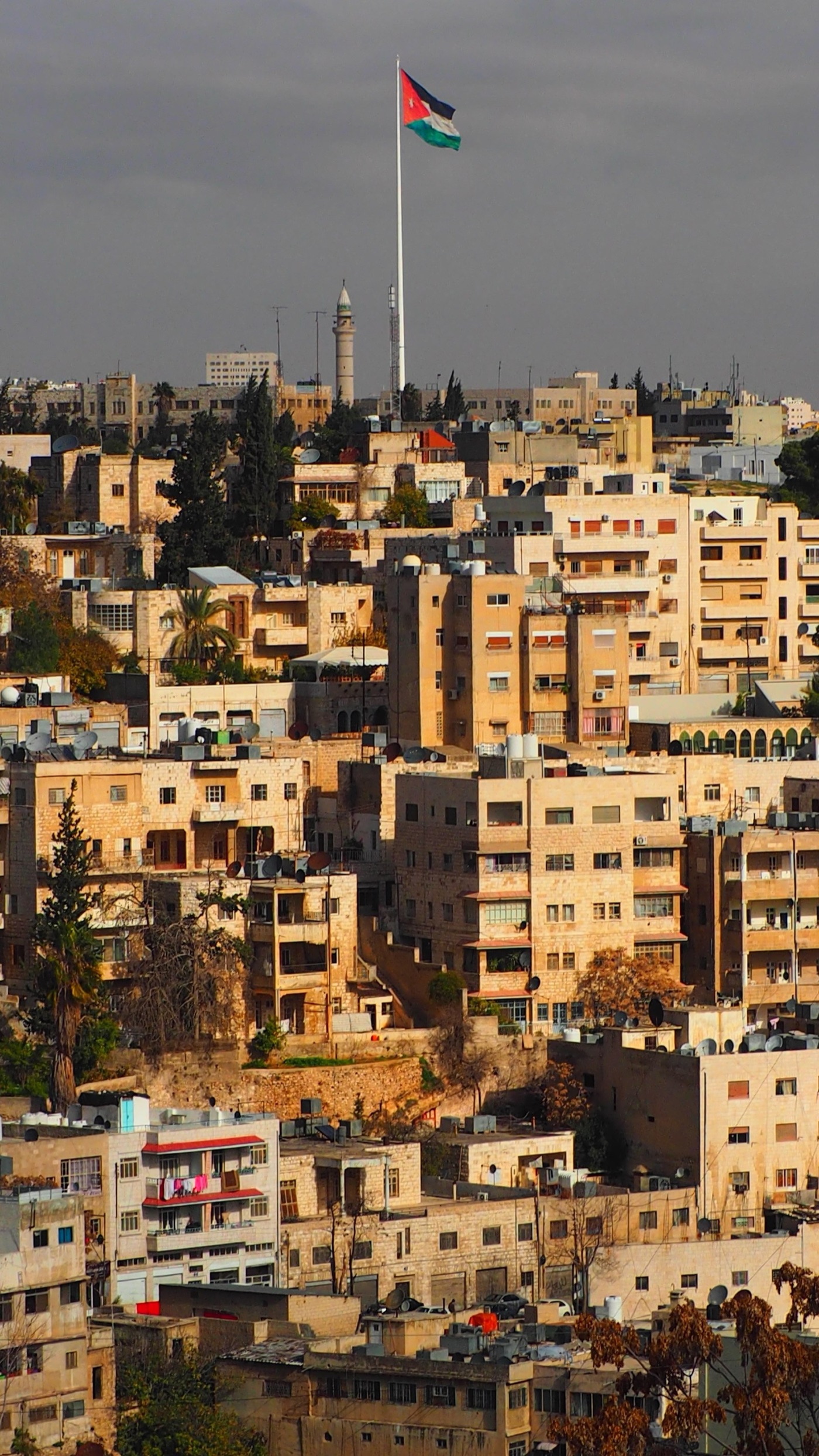 The hillsides of Amman. Every roof carries the tanks that hold the week's delivery.