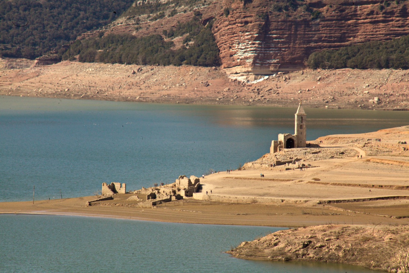 The Sau reservoir at thirteen percent, with the drowned village of Sant Romà back above the water.