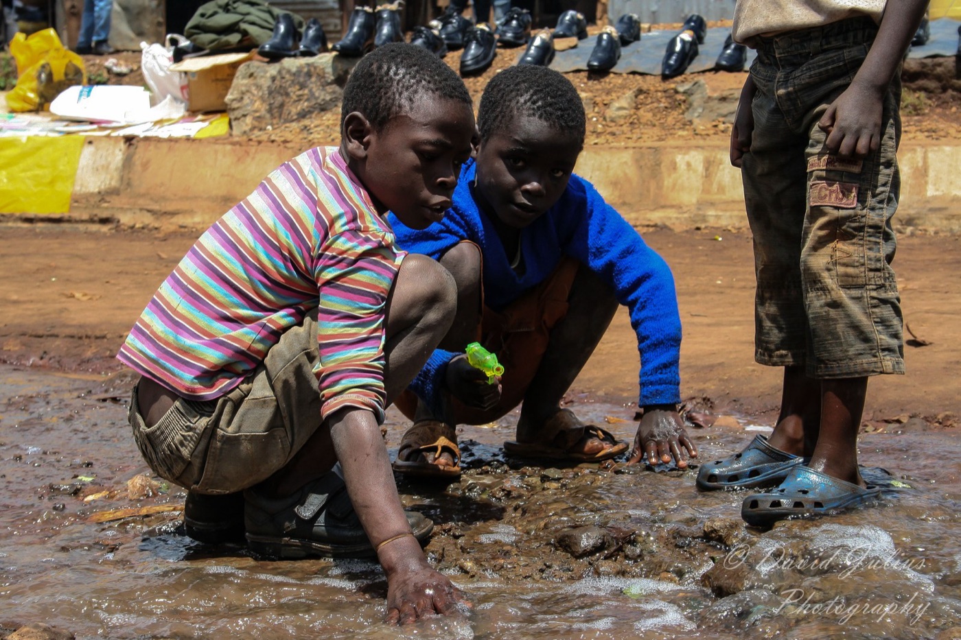 Water in Kibera. A third of the city lives where the pipe never came, and pays the most per litre.